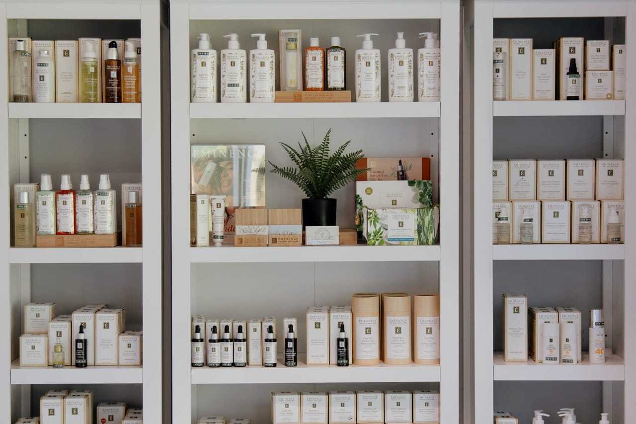 Shelves with various skincare products and a potted plant in the center.